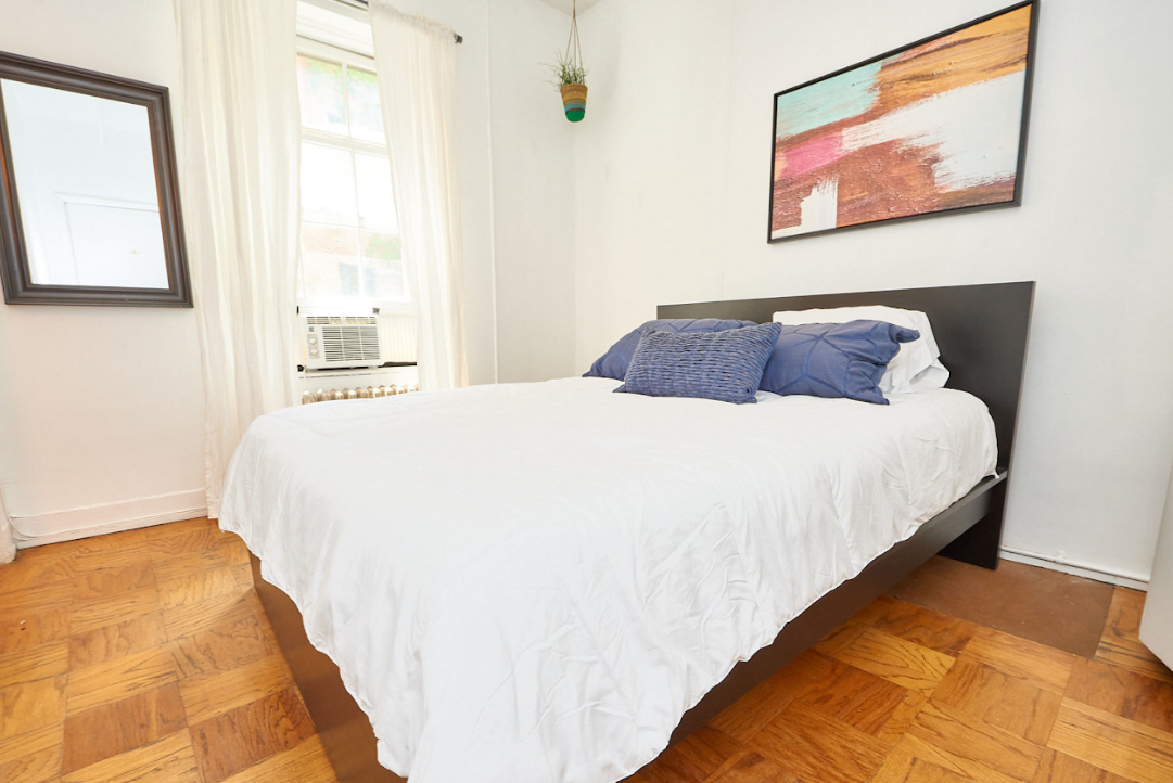 120 East 10th Street, Unit 3 Manhattan, NY 10003 - Photo 8 of 14 a large bed sitting in a bedroom next to a window