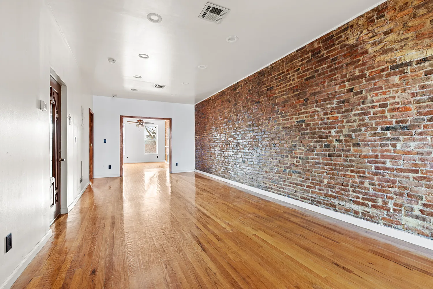 a view of empty room with wooden floor