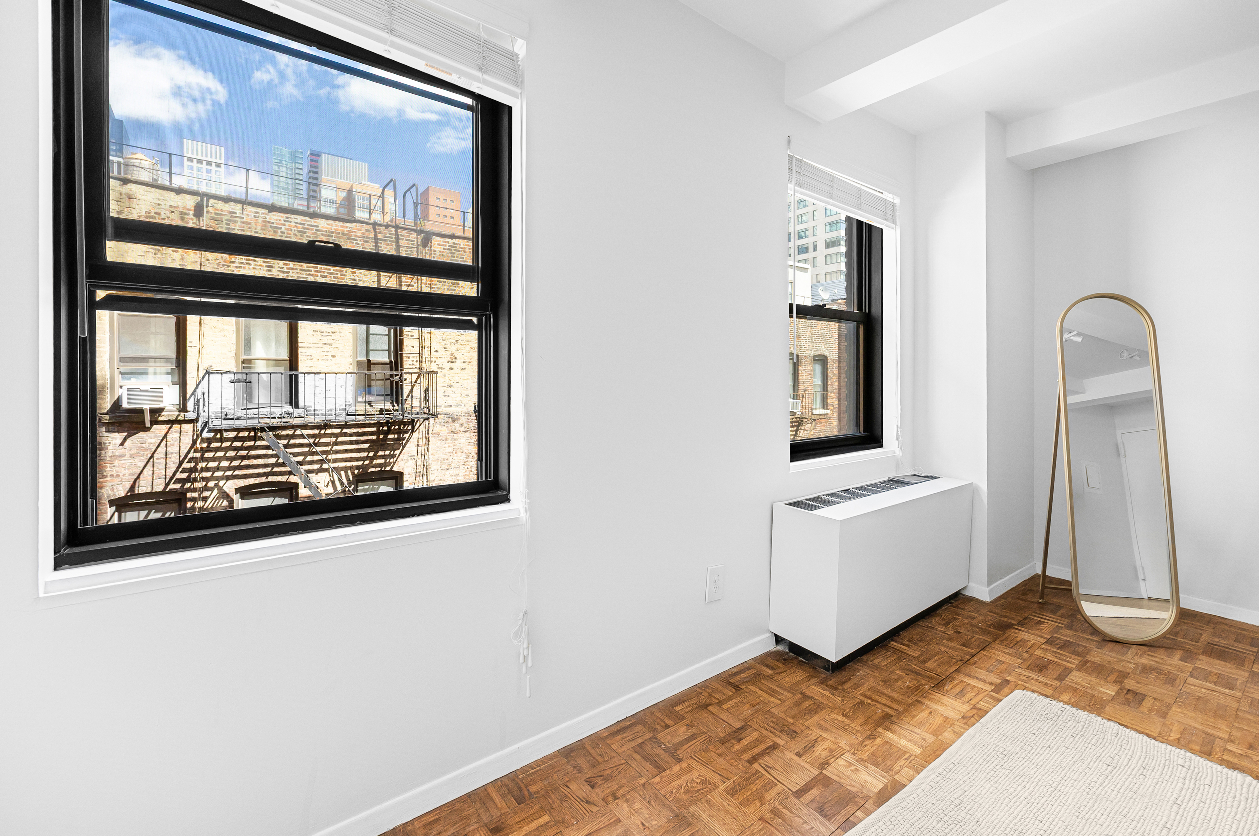 235 East 49th Street, Unit 6G Manhattan, NY 10017 - Photo 2 of 22 a view of a livingroom with wooden floor and a large window