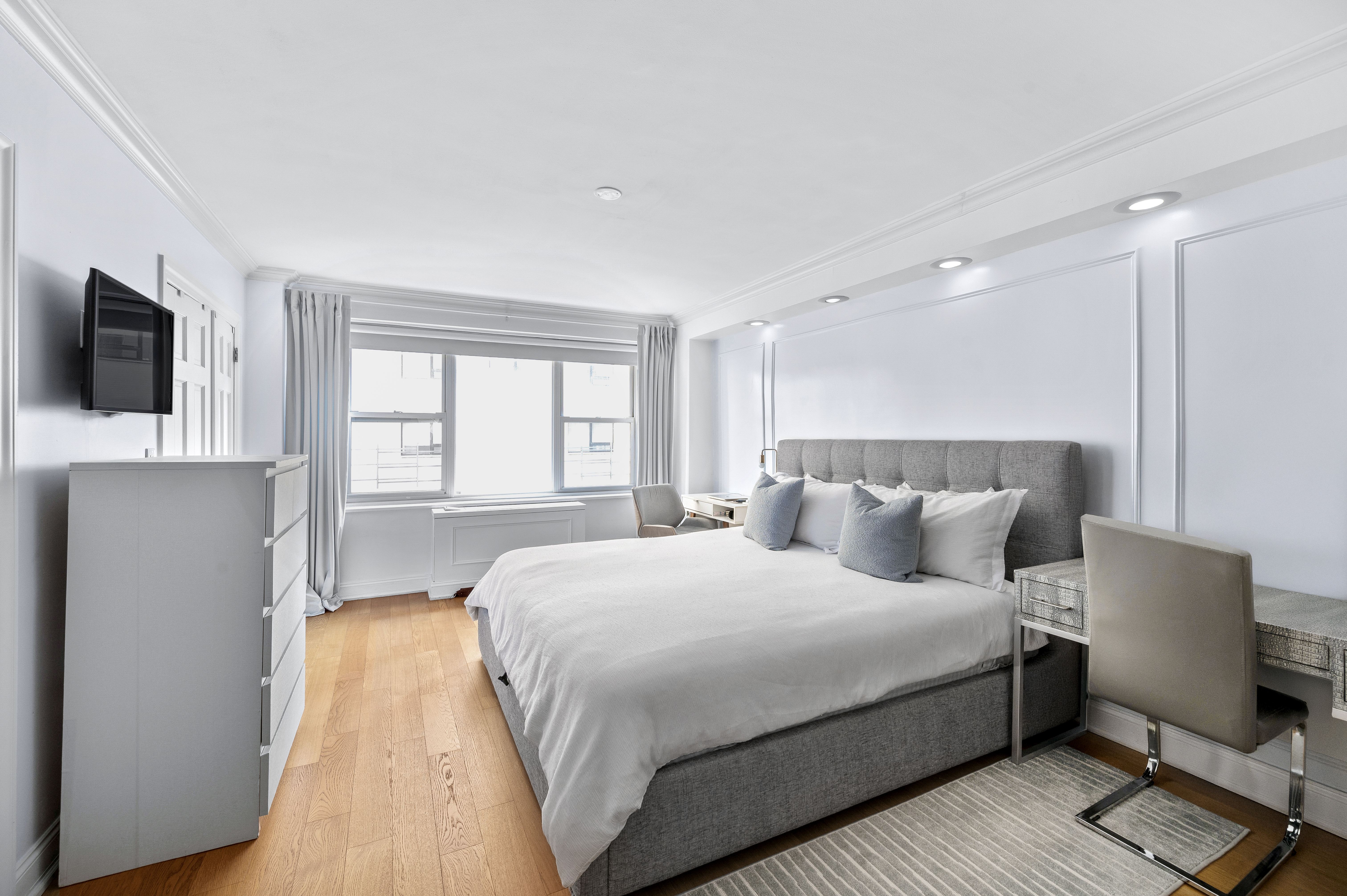 201 East 79th Street, Unit 6A Manhattan, NY 10075 - Photo 8 of 11 a bedroom with a bed and a flat screen tv