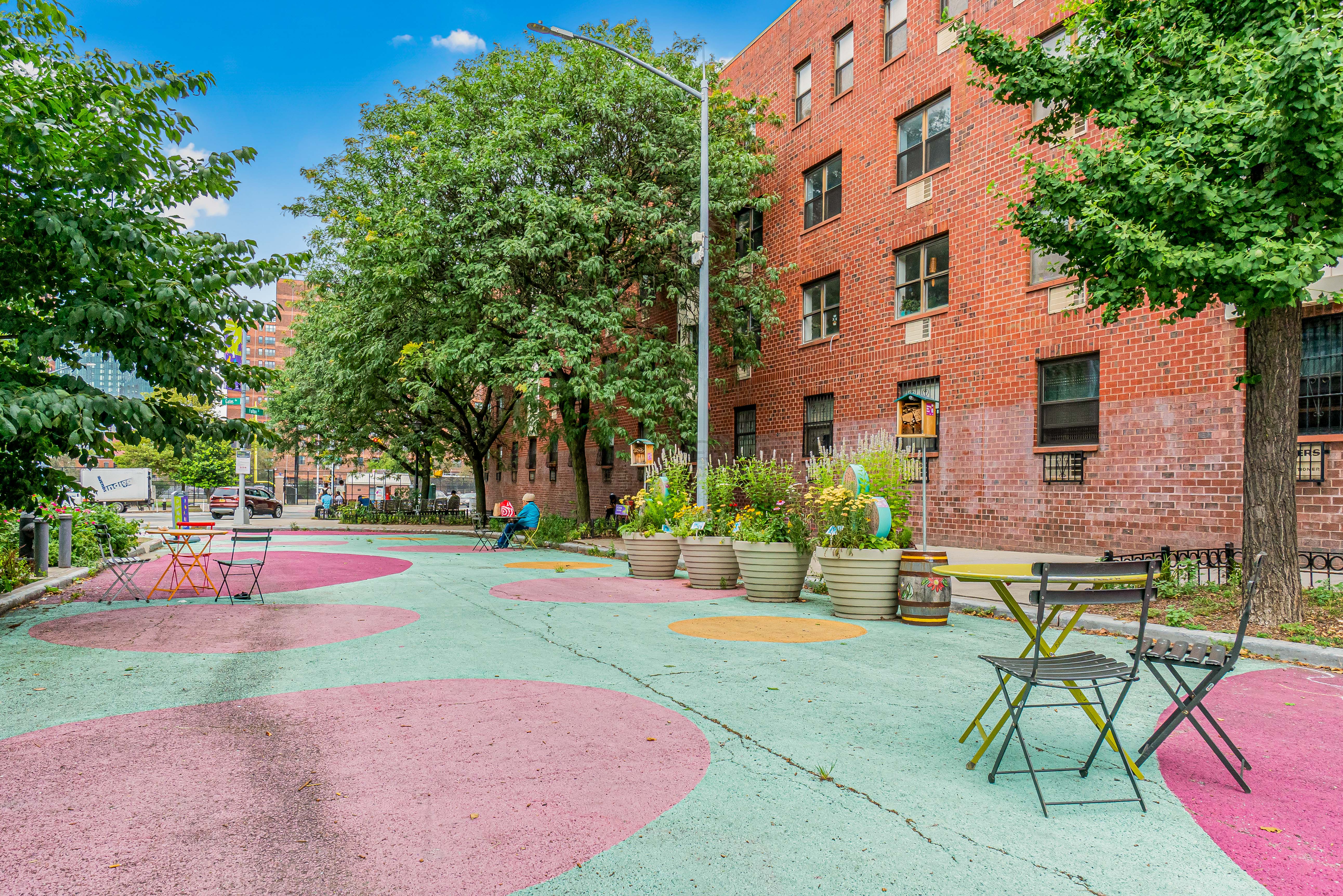 7 Gates Avenue, Unit H Brooklyn, NY 11238 - Photo 19 of 20 a view of a backyard with table and chairs and potted plants and large tree