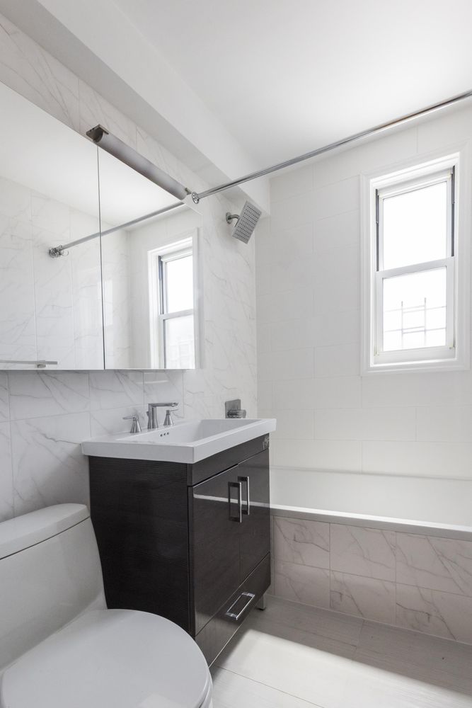 1270 5th Avenue, Unit 12C Manhattan, NY 10029 - Photo 12 of 18 a bathroom with a sink toilet and mirror