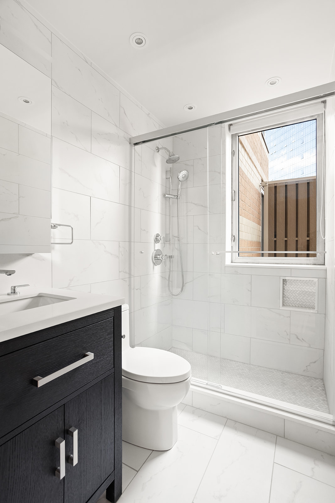 500 West 43rd Street, Unit 3B Manhattan, NY 10036 - Photo 7 of 19 a bathroom with a granite countertop sink a toilet and shower