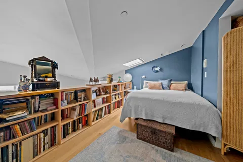 a bedroom with a bed a book shelf and a book shelf