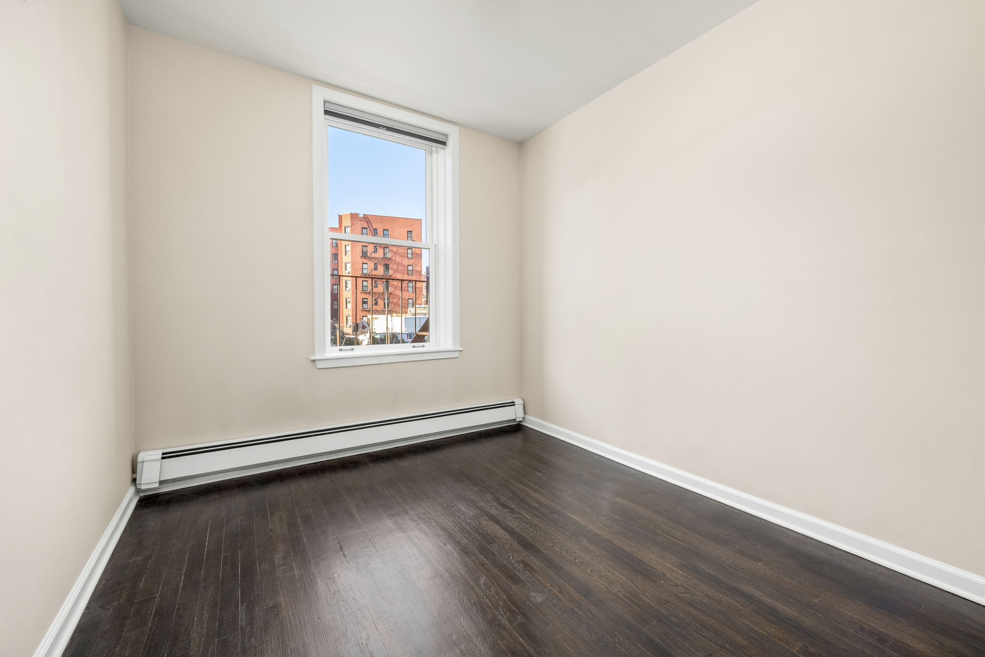 160 West 11th Street, Unit 1 Manhattan, NY 10011 - Photo 14 of 18 an empty room with wooden floor and windows