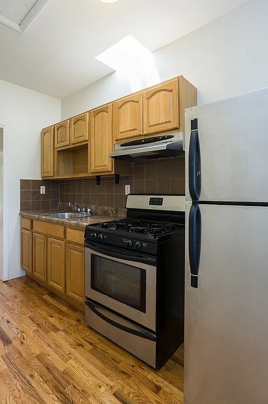 a kitchen with stainless steel appliances granite countertop a stove a microwave and a refrigerator