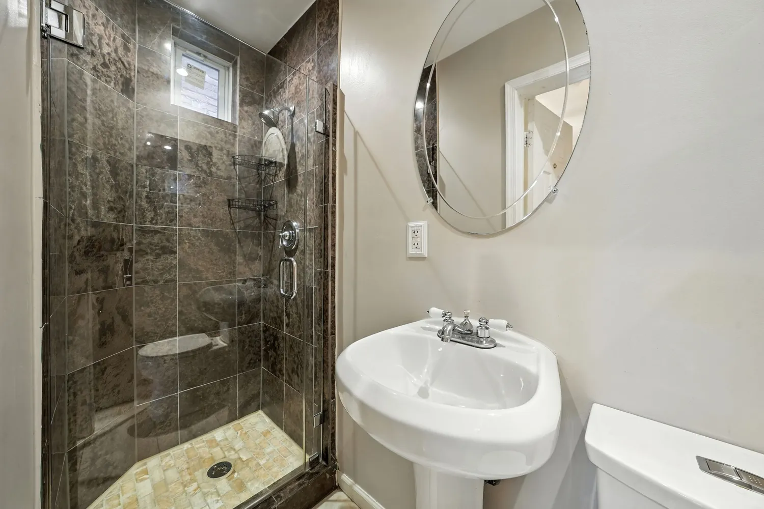 a bathroom with a sink a toilet and shower