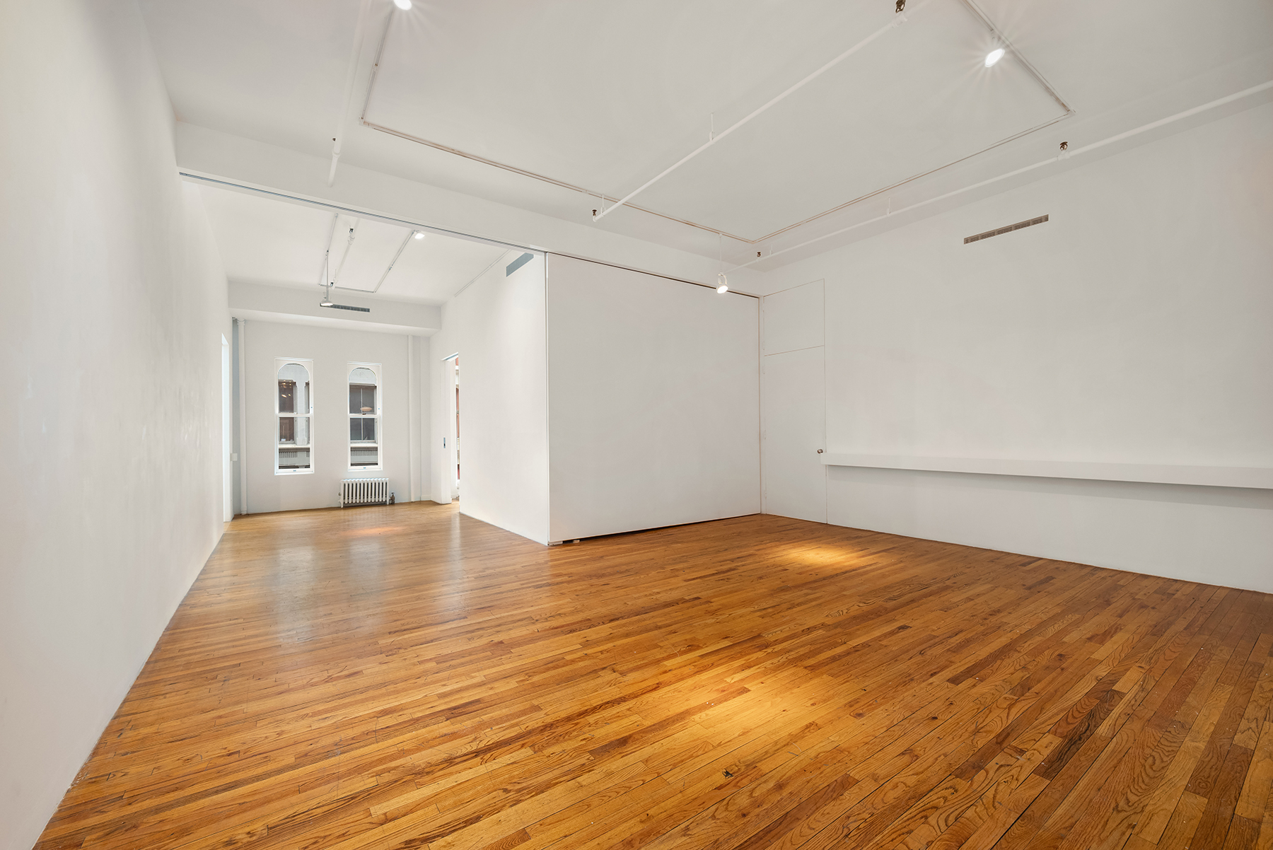 59 Wooster Street Manhattan, NY 10012 - Photo 4 of 10 a view of empty room with wooden floor and fan