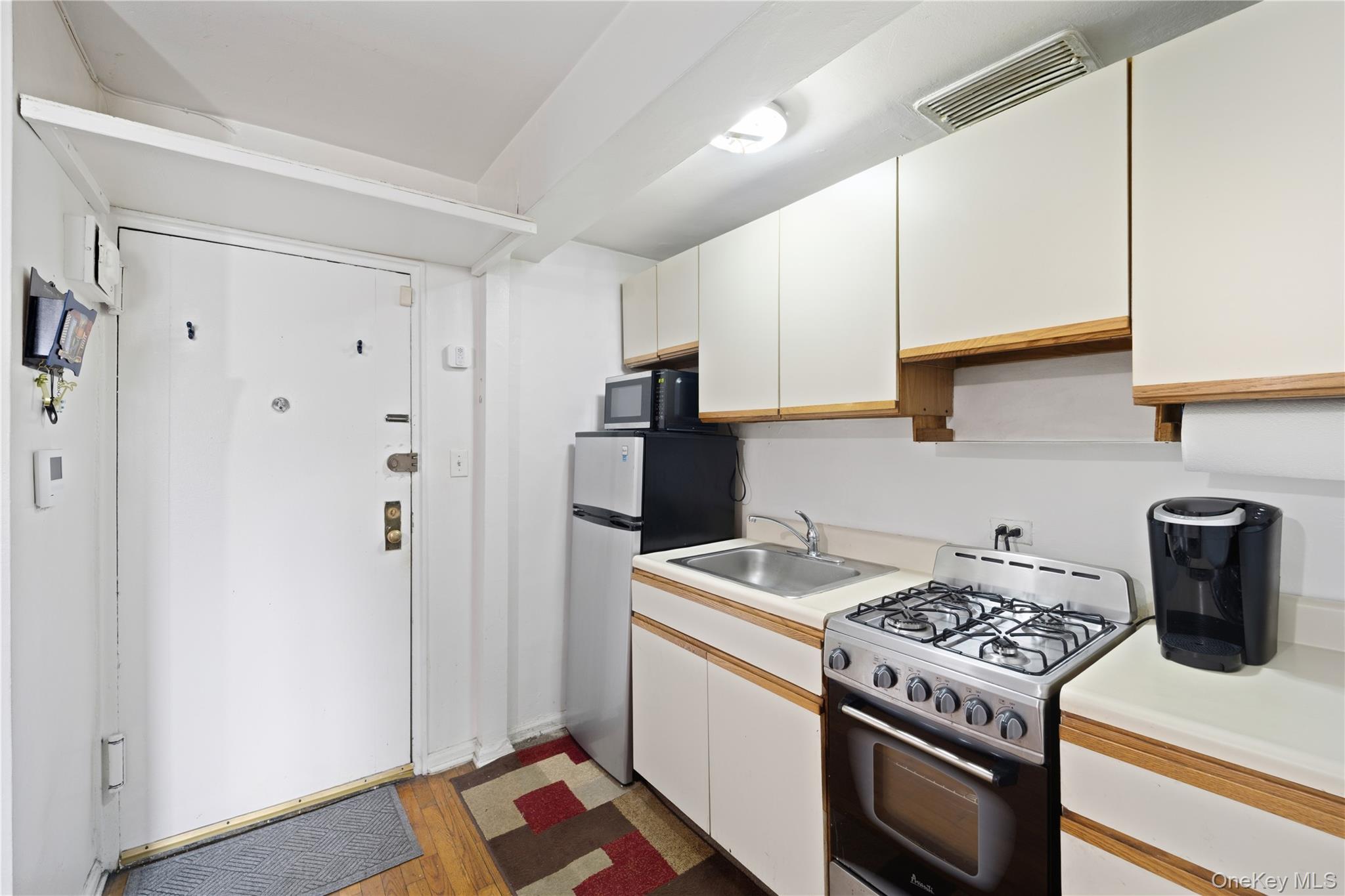73-11 Bell Boulevard, Unit 2C Queens, NY 11364 - Photo 12 of 16 a kitchen with a stove and a refrigerator