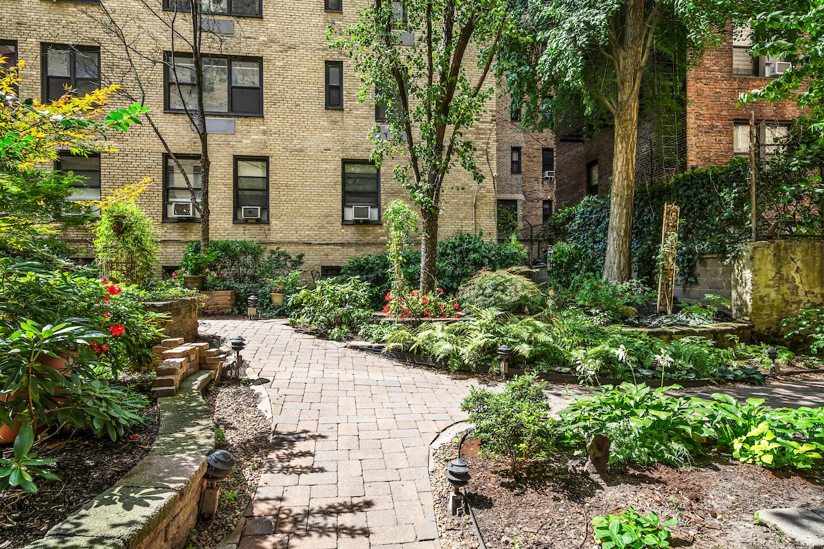 a view of a building with potted plants and large trees