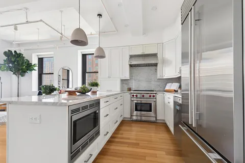 a kitchen with stainless steel appliances a stove a sink and a refrigerator