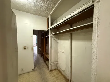 a view of walk in closet with empty racks