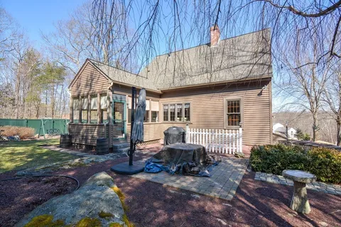 a view of a house with backyard and sitting area