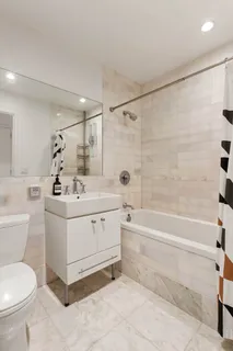 a bathroom with a double vanity sink toilet and shower