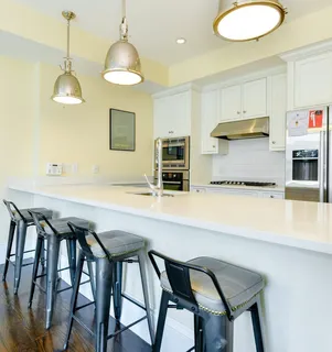 a kitchen with stainless steel appliances a table and chairs in it