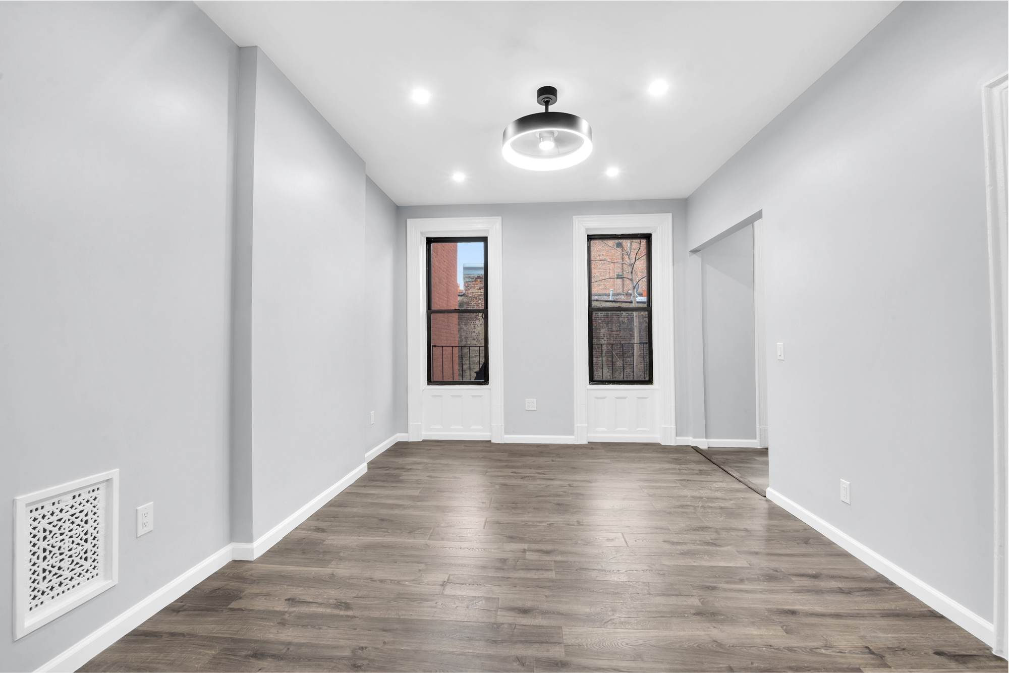 316 Lewis Avenue, Unit 2 Brooklyn, NY 11221 - Photo 4 of 8 an empty room with wooden floor and windows