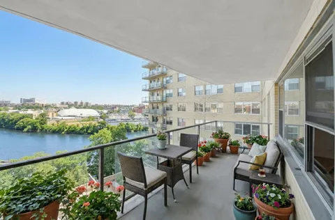 a view of a balcony with chairs and a potted plant