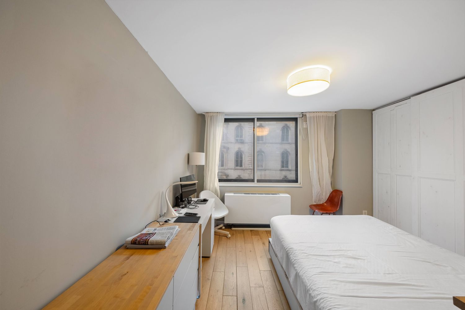 a bedroom with a bed and a large window