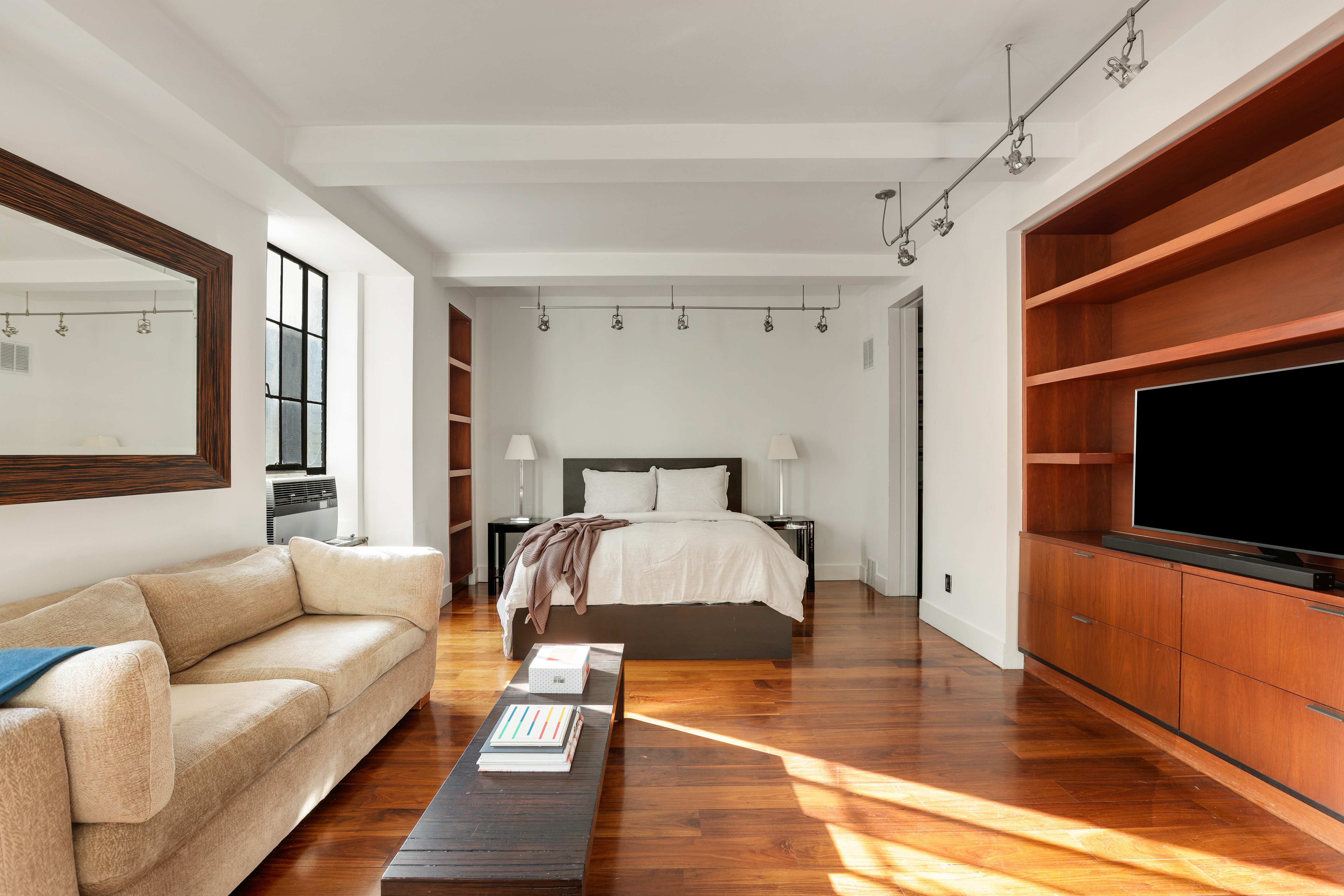 340 West 57th Street, Unit 8E Manhattan, NY 10019 - Photo 6 of 16 a living room with furniture and a flat screen tv