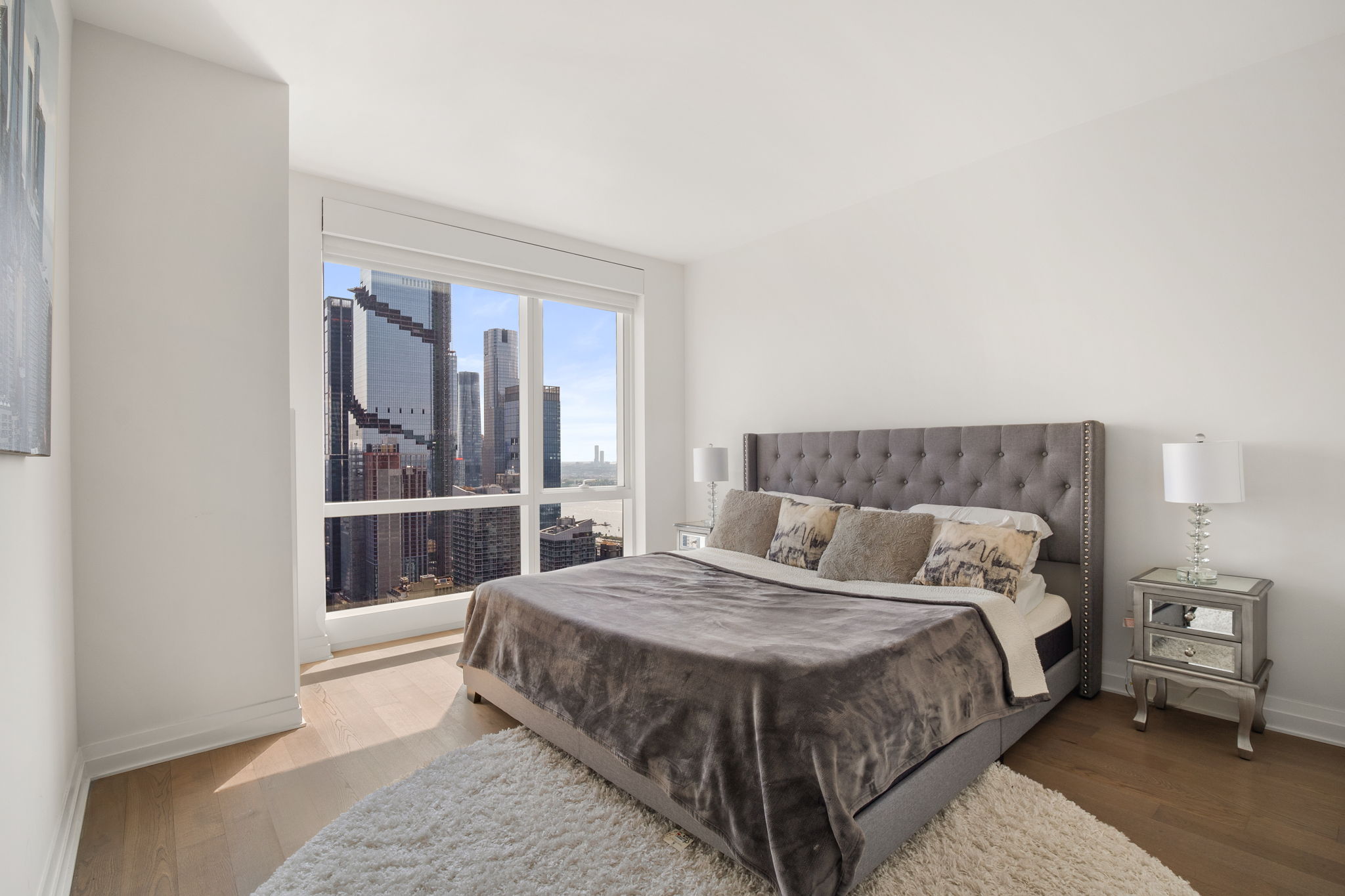 460 West 42nd Street, Unit 55F Manhattan, NY 10036 - Photo 6 of 9 a bed sitting in a bedroom next to a window