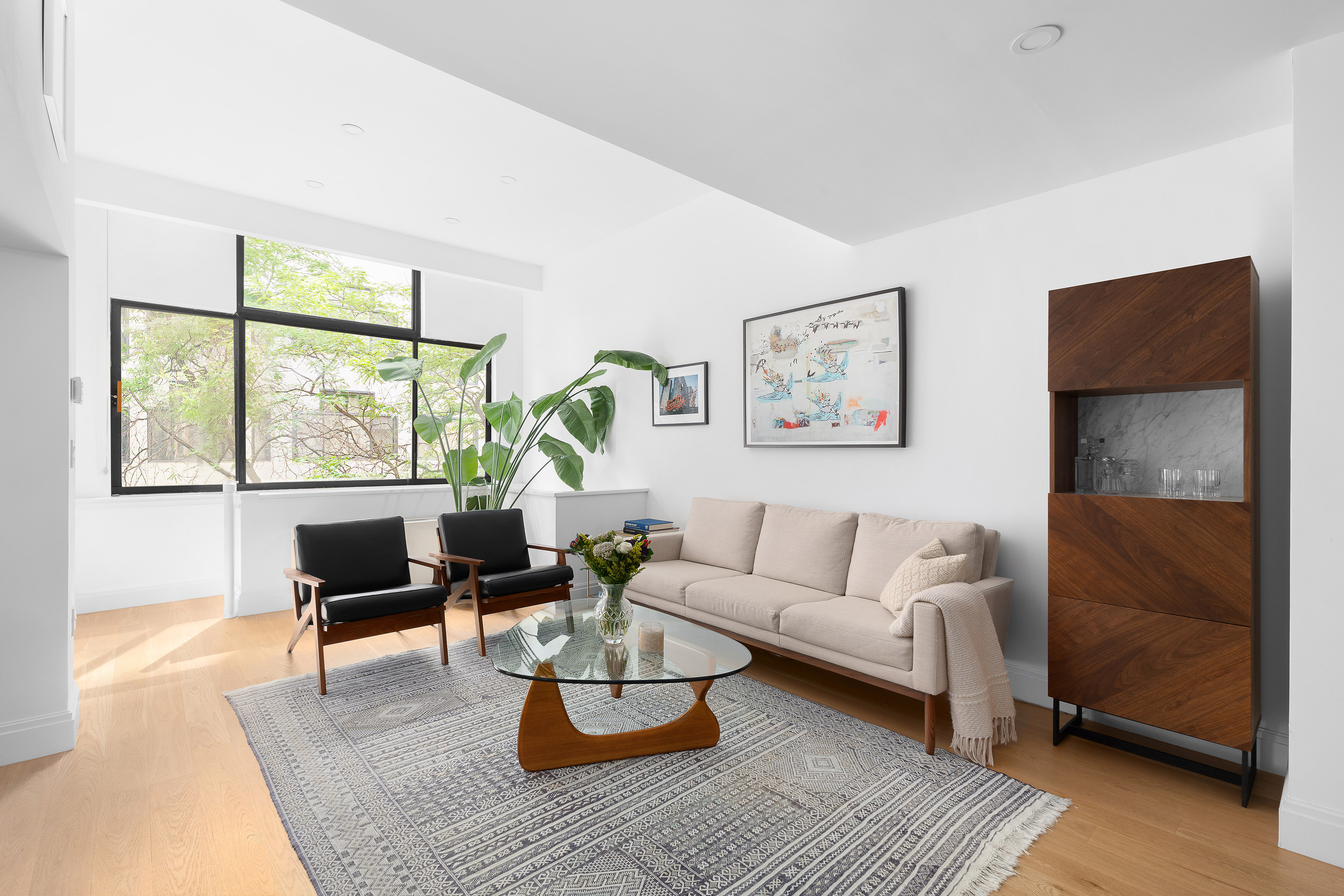 77 Bleecker Street, Unit 123E Manhattan, NY 10012 - Photo 1 of 13 a living room with furniture large window and wooden floor