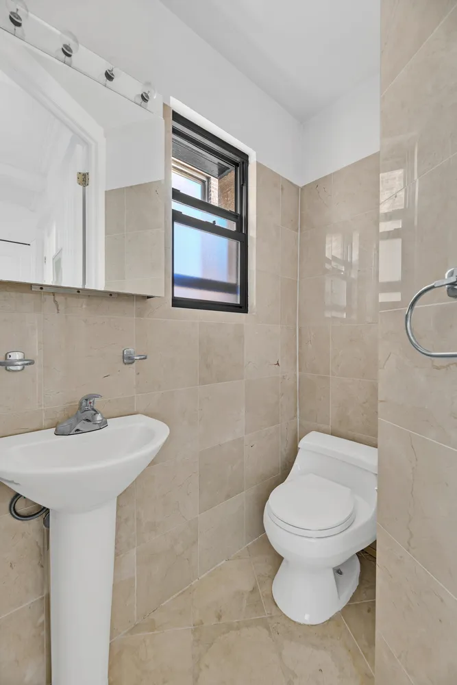 a bathroom with a toilet sink and mirror