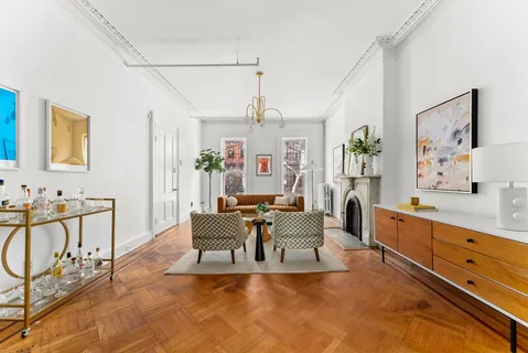 a living room with furniture and paintings on the wall