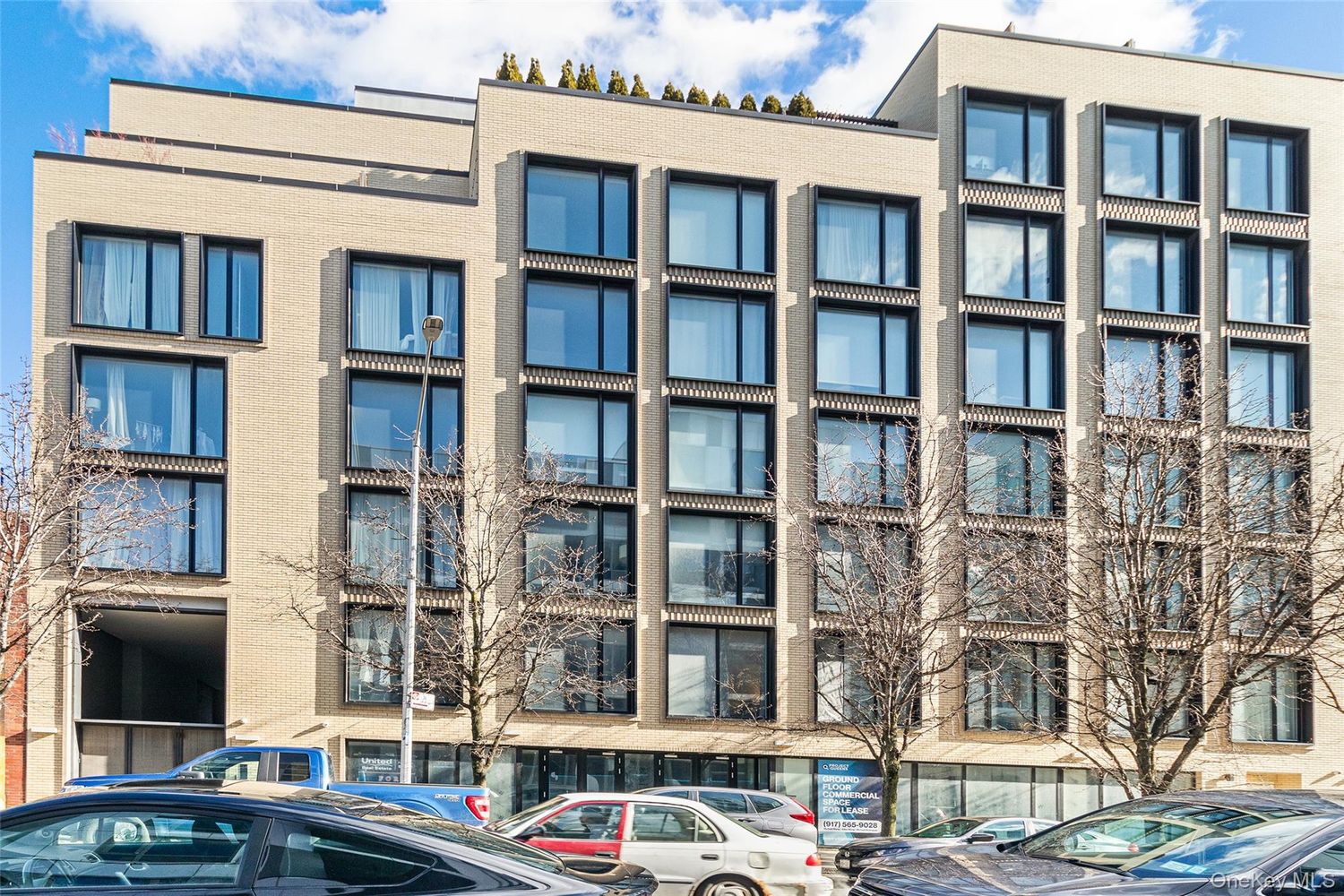 37-14 34th Street, Unit N3E Queens, NY 11101 - Photo 15 of 18 a front view of a residential apartment building with a yard