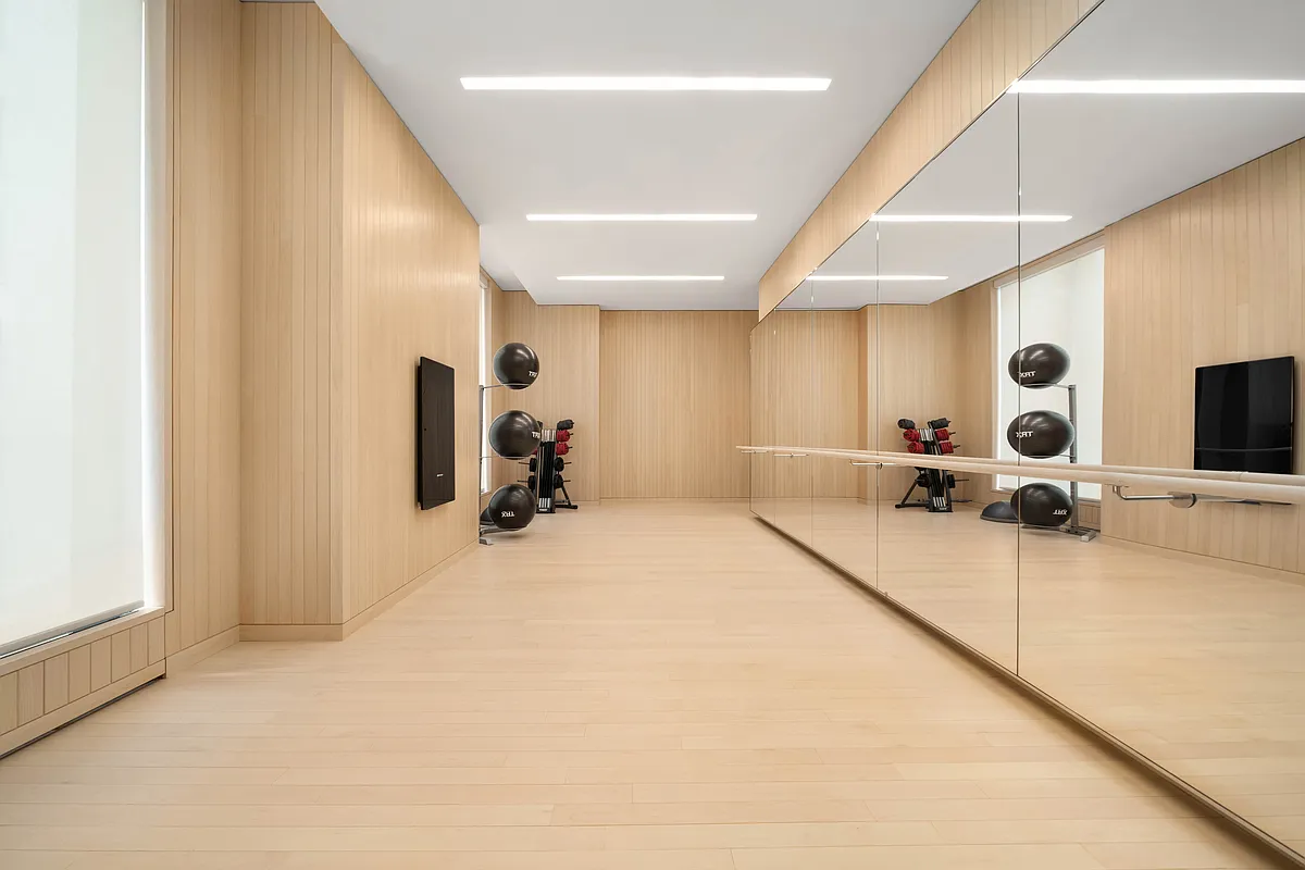 430 East 58th Street, Unit 16A Manhattan, NY 10022 - Photo 15 of 22 a spacious bedroom with a large bed and a flat tv screen on the wall