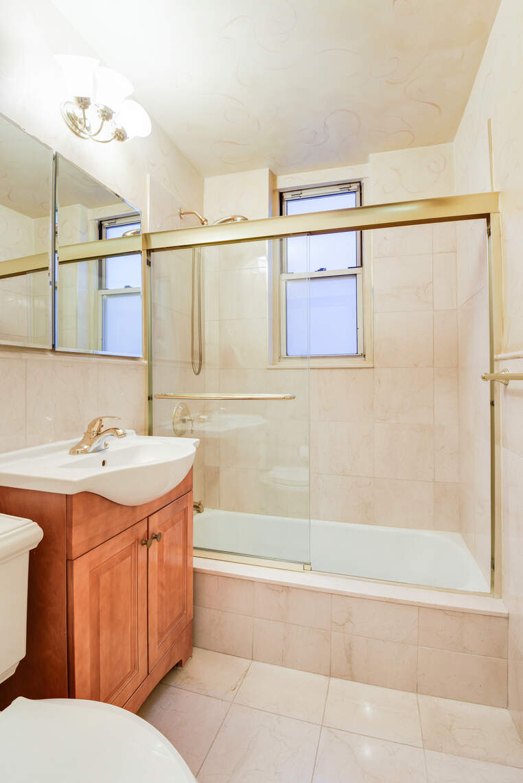 222 East 80th Street, Unit 3A Manhattan, NY 10075 - Photo 10 of 16 a bathroom with a sink a toilet and shower