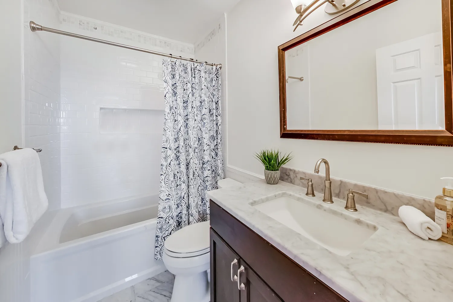 a bathroom with a granite countertop sink toilet and shower