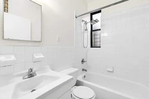 a bathroom with a bathtub sink and mirror