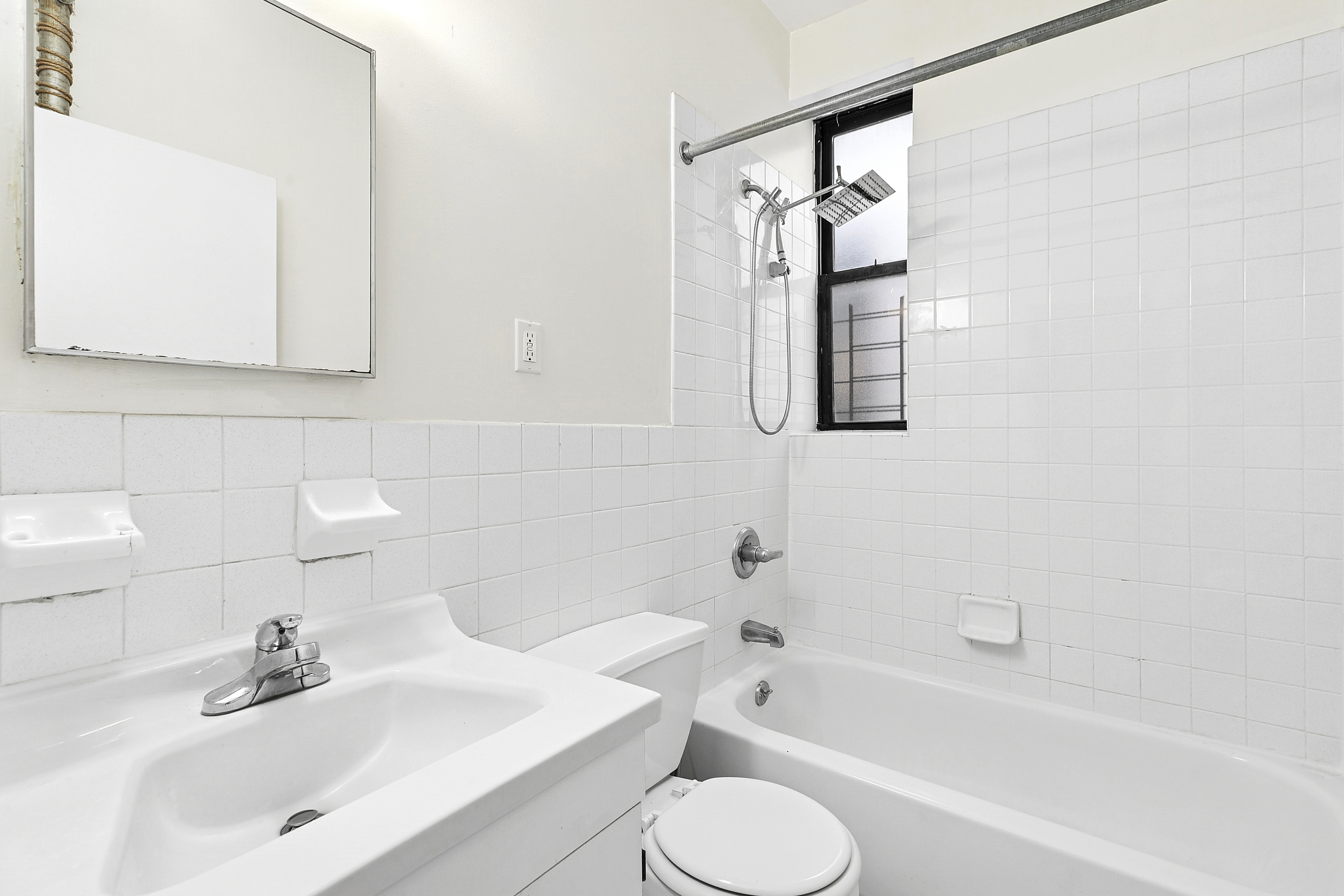 11 St Nicholas Avenue, Unit 5B Manhattan, NY 10026 - Photo 8 of 10 a bathroom with a bathtub sink and mirror