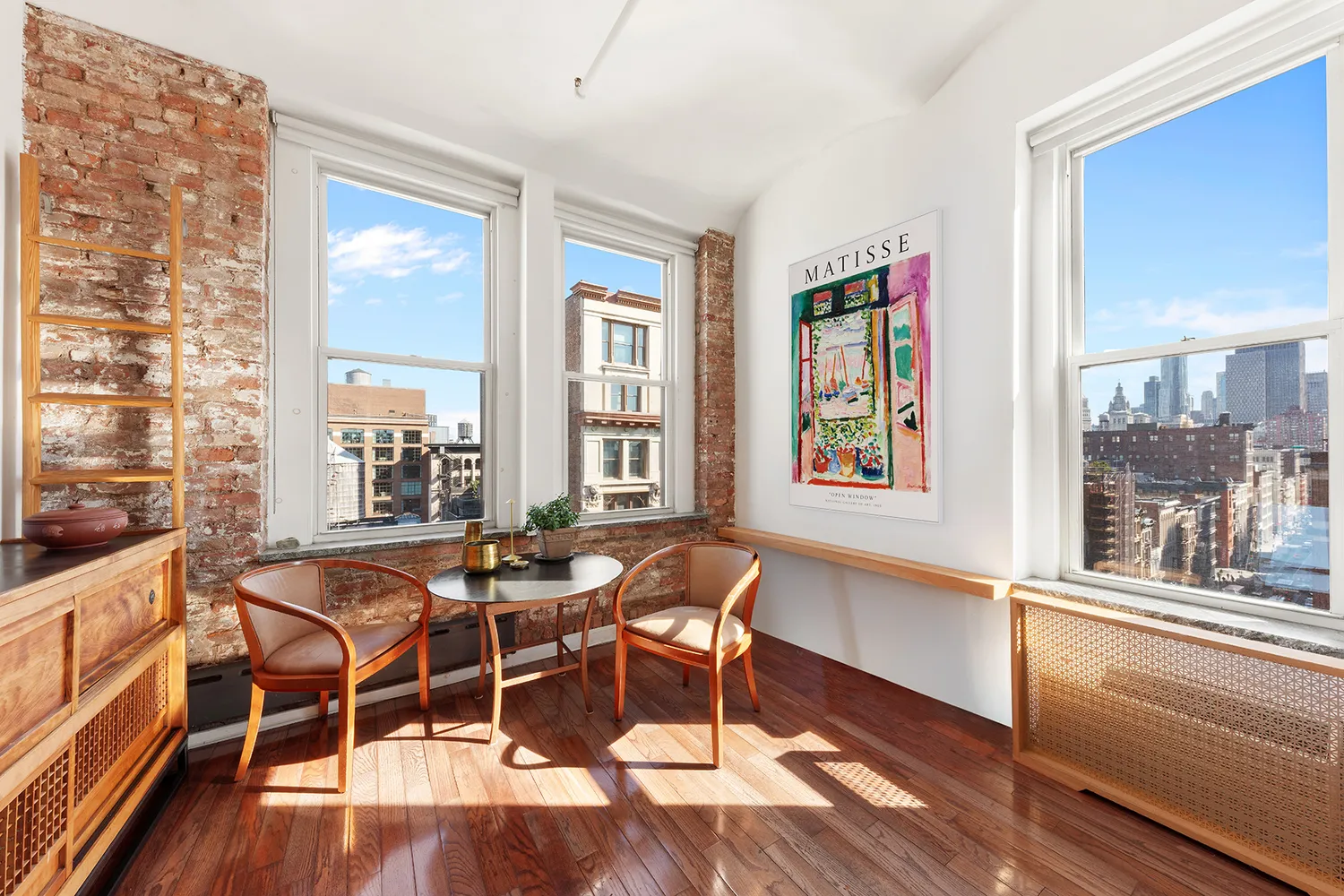 a dining room with wooden floor and large windows