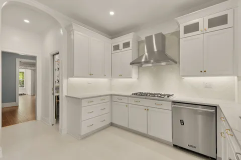 a kitchen with white cabinets and appliances