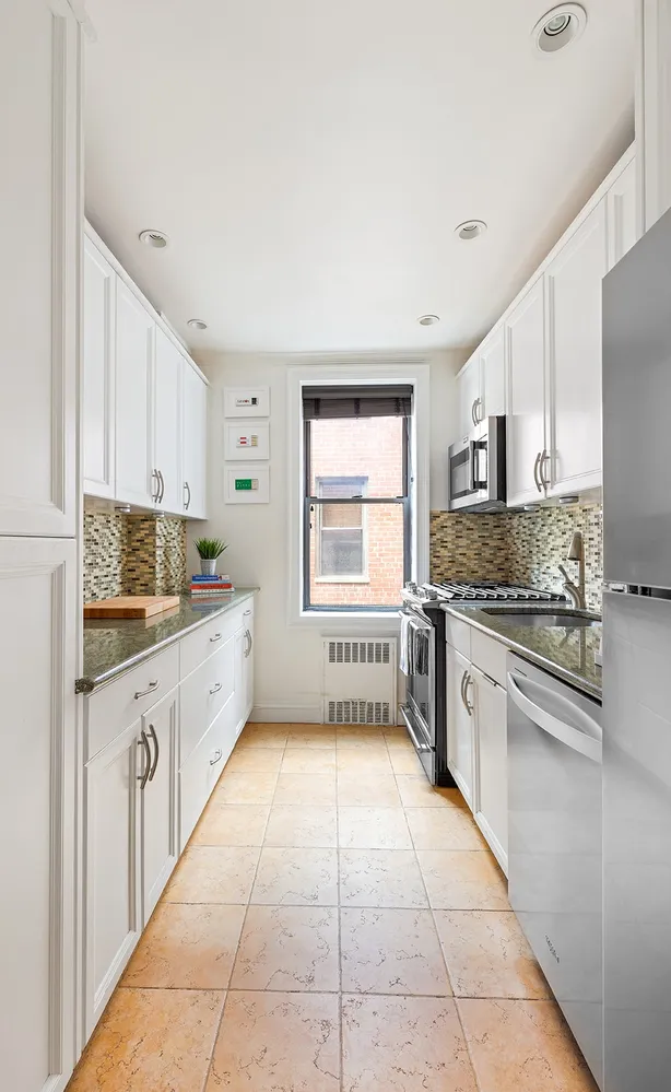 a large kitchen with cabinets and window