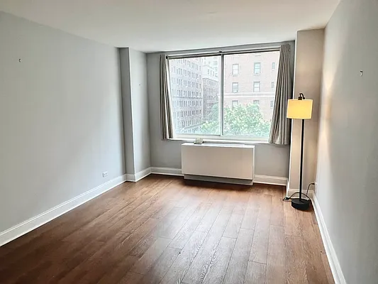 250 West 90th Street, Unit 6I Manhattan, NY 10024 - Photo 12 of 15 an empty room with wooden floor and windows