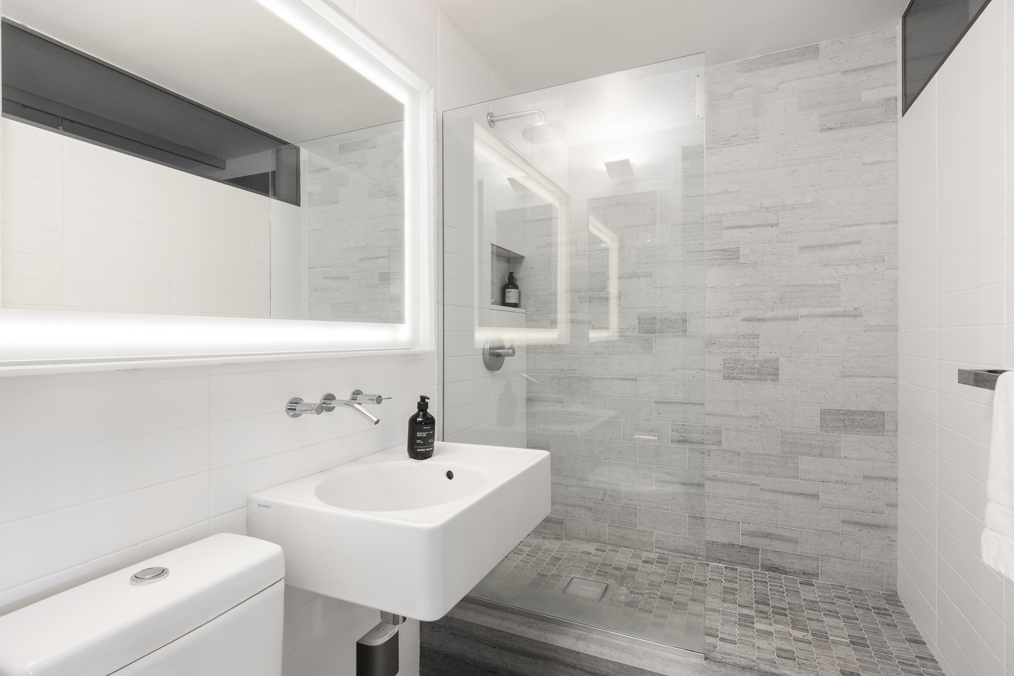 2 Charlton Street, Unit 11LM Manhattan, NY 10014 - Photo 9 of 16 a bathroom with a sink a toilet and a mirror