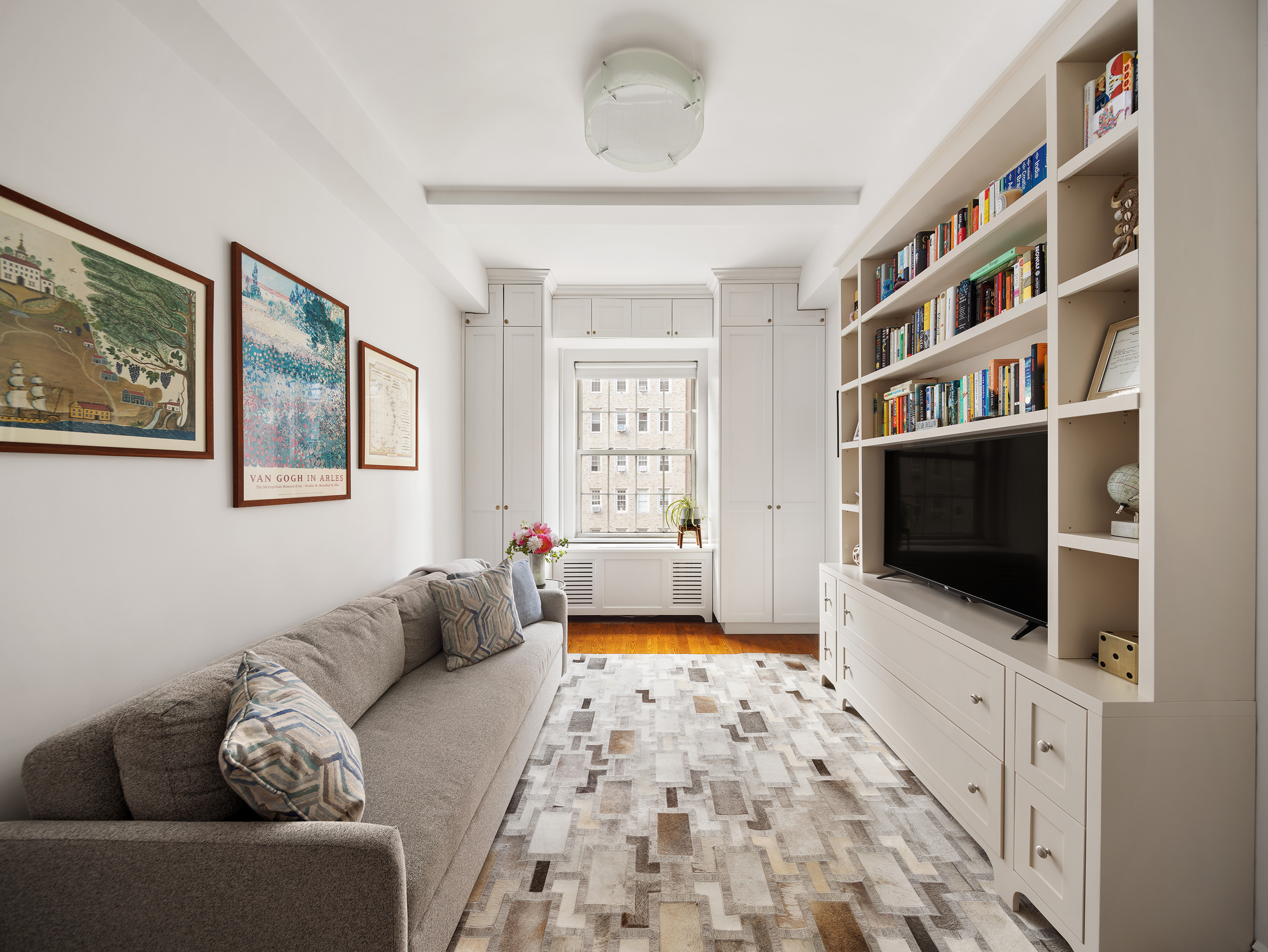 25 5th Avenue, Unit 8F Manhattan, NY 10003 - Photo 6 of 9 a living room with furniture and a flat screen tv