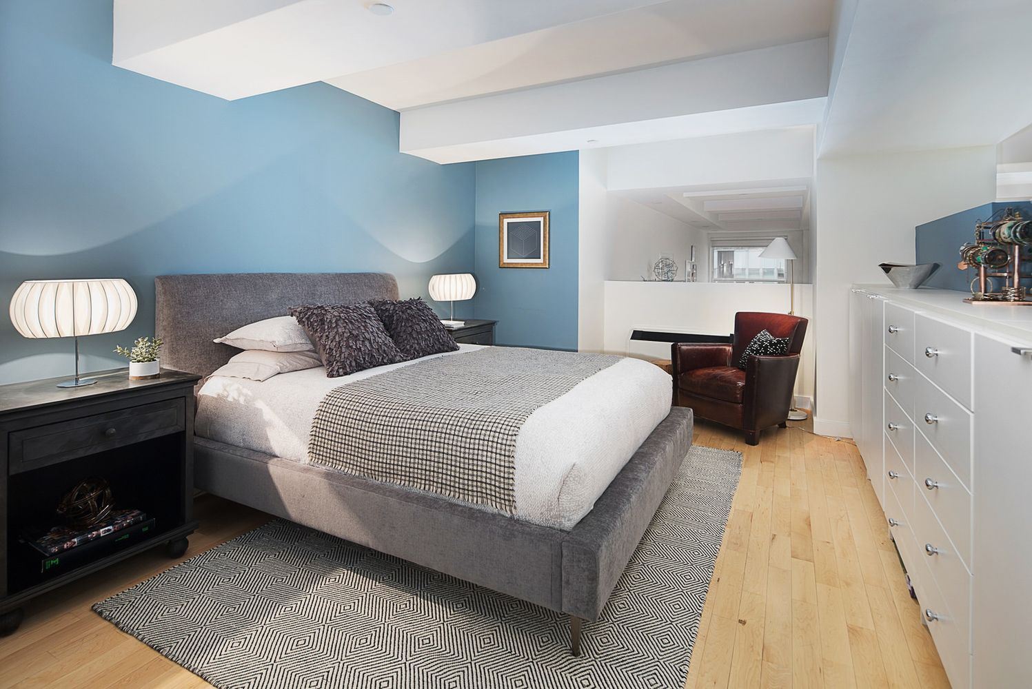 a spacious bedroom with a bed and dresser