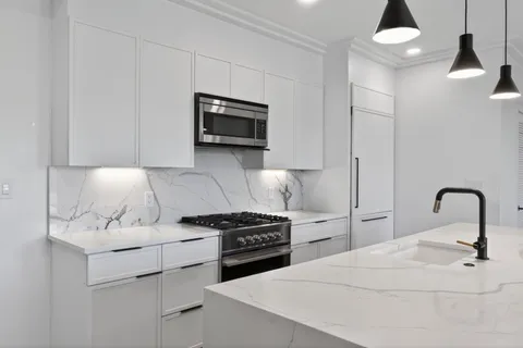 a kitchen with stainless steel appliances a white cabinet and a stove top oven