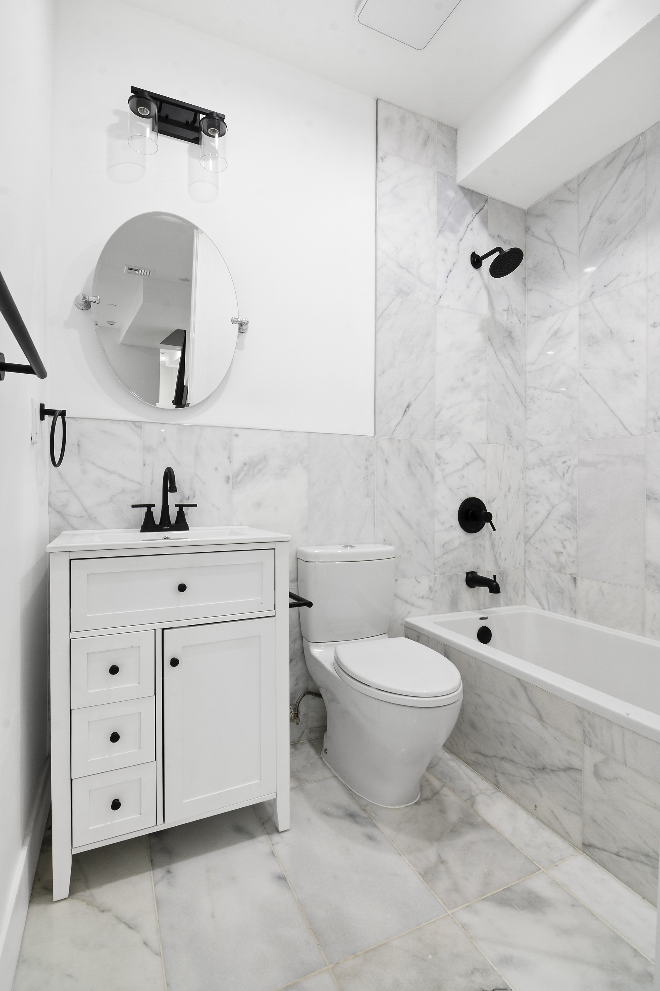 1085 Hancock Street Brooklyn, NY 11221 - Photo 6 of 9 a bathroom with a toilet a sink a mirror a bathtub and shower