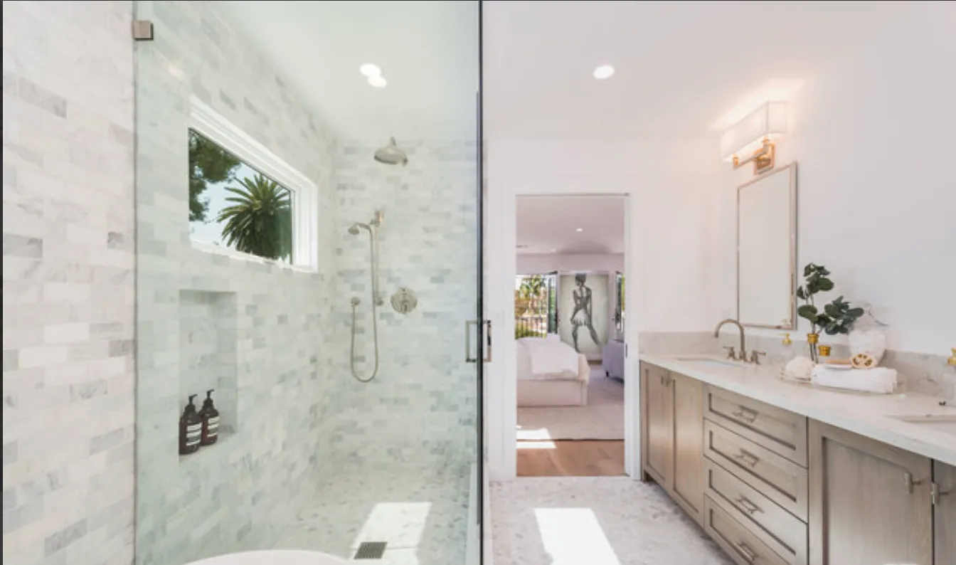 a bathroom with a double vanity sink a toilet and shower