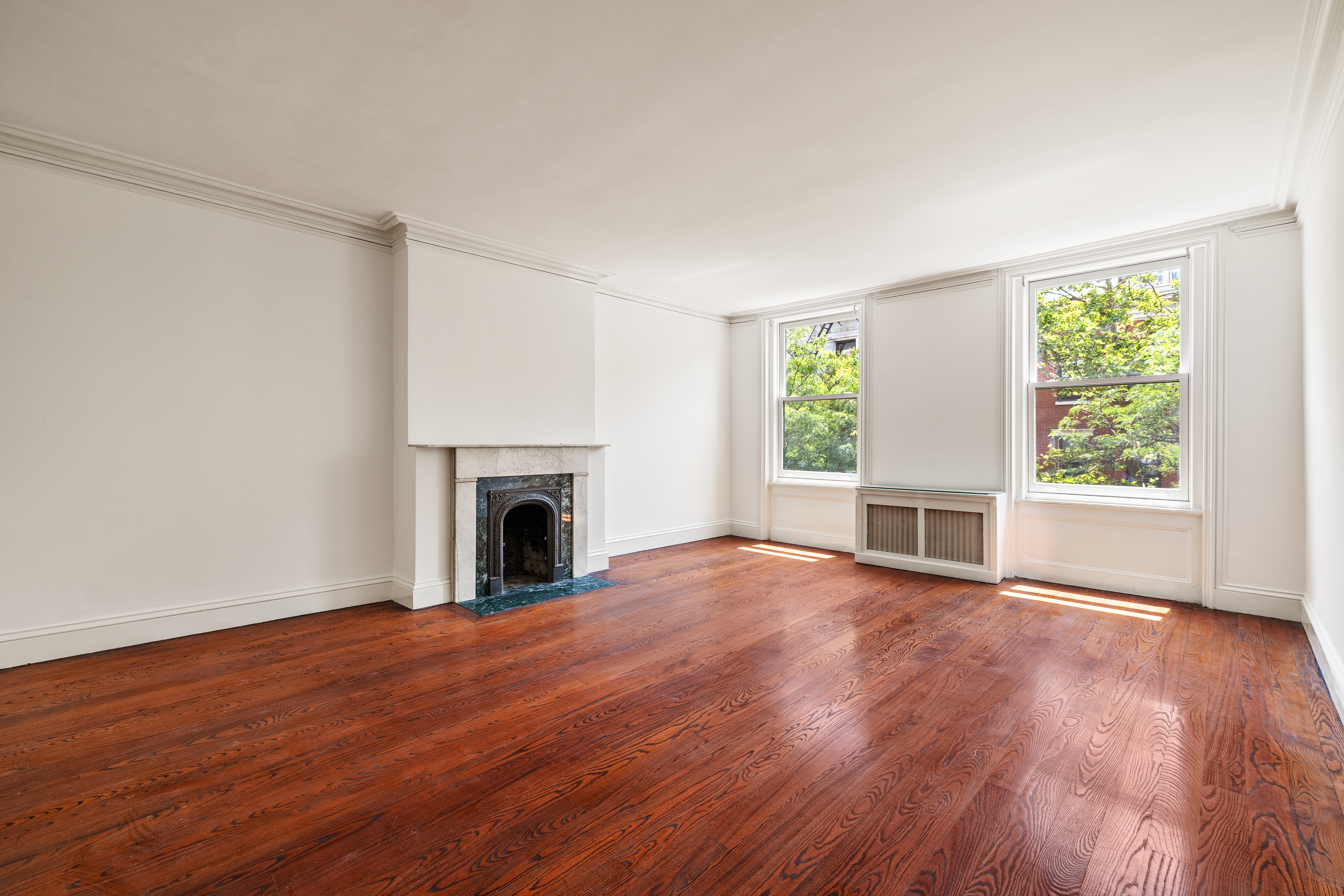 225 West 22nd Street Manhattan, NY 10011 - Photo 8 of 12 a view of empty room with wooden floor and fireplace