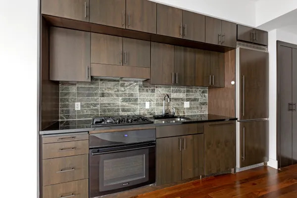 a kitchen with appliances cabinets and a wooden floor