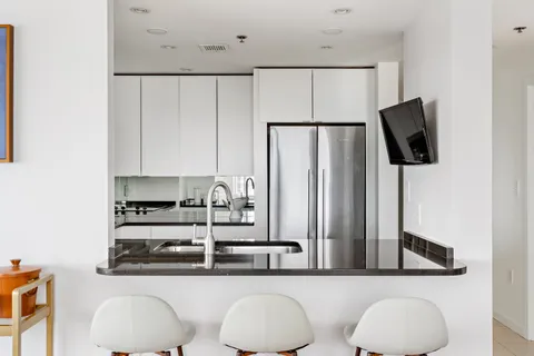a kitchen with stainless steel appliances white cabinets and a refrigerator
