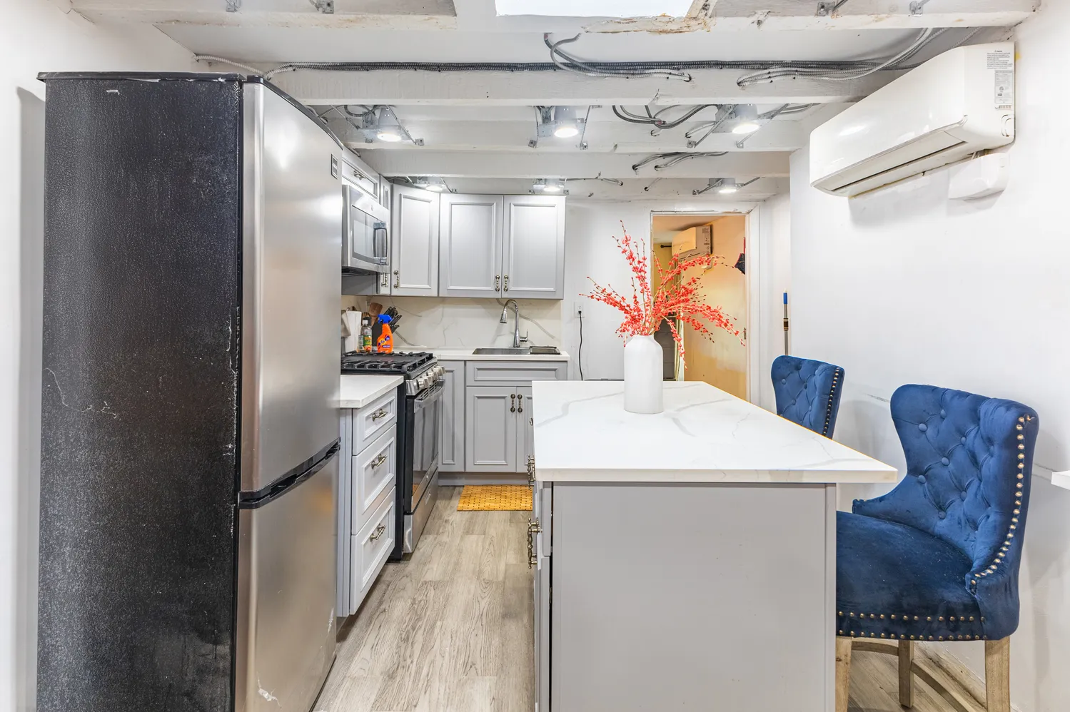 a kitchen with refrigerator and chairs