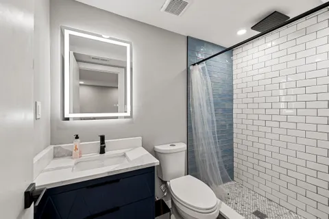 a bathroom with a sink a toilet and shower