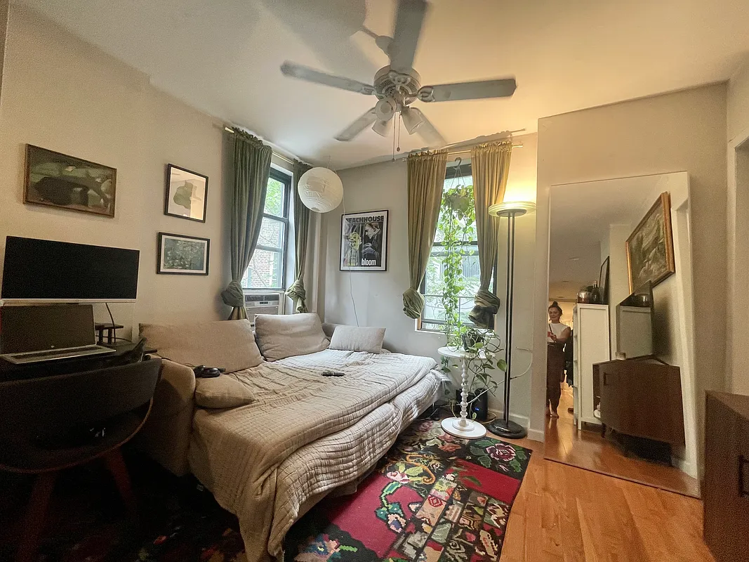 210 Thompson Street, Unit 4DN Manhattan, NY 10012 - Photo 5 of 10 a bedroom with a bed and a flat screen tv