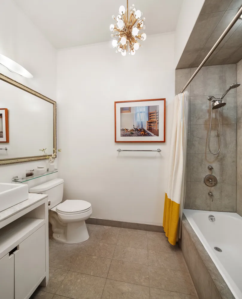 a bathroom with a tub a sink and a large mirror